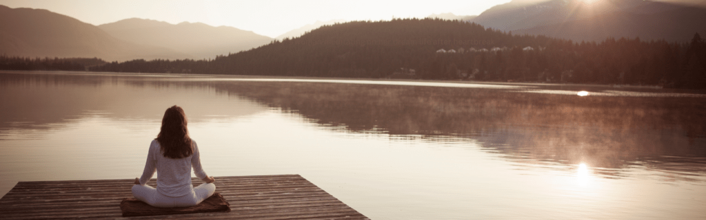 Woman meditating to manifest her best life after heartbreak